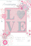 This anniversary card offers a gentle celebration of lasting romance, blending soft pastel pinks and misty greys into a design that feels both intimate and refined, much like a thoughtfully curated bouquet delivered across Brentwood. At the centre, the word LOVE is elegantly spelled out in softly raised glitter, the letters outlined in luminous silver. The letter O is transformed into a shimmering heart, richly textured with tiny reflective particles that catch and play with the light, inviting fingertips to linger. Around this focal point, delicate blossoms in blush, mauve, and hints of ivory unfurl with a watercolour softness, their edges defined by fine, flowing lines that suggest care and artistry. Slim vines and tendrils weave between the flowers, adding a sense of quiet movement, as though stirred by a gentle breeze drifting through the trees at King George's Playing Fields. Scattered petals, curled flourishes, and tiny, almost-hidden butterflies contribute to a feeling of whimsical grace, like an English spring garden captured on card. The phrases On Our Anniversary and I love you today and always appear in graceful, understated script, placed so they nestle naturally among the blossoms rather than dominating the design. The card's textures-smooth background, raised glitter, and crisp printing-combine to create a multilayered sensory experience. Together, these elements form a composition that feels soft as a whisper yet emotionally profound, perfectly suited as a keepsake for marking a couple's shared journey and treasured memories in Brentwood.